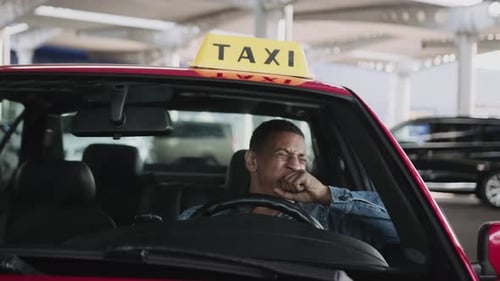 Sleepy Taxi Driver Drinks Coffee in Red Cab