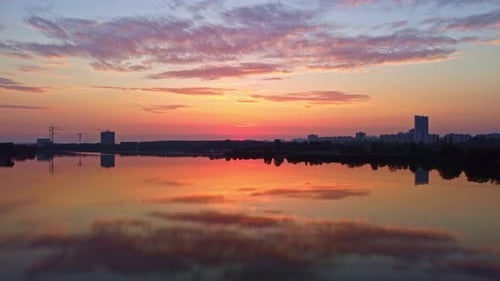 Sunrise on river with clouds reflecting in water