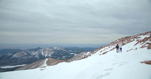 Couple Hiking Rocky Mountains in Snow