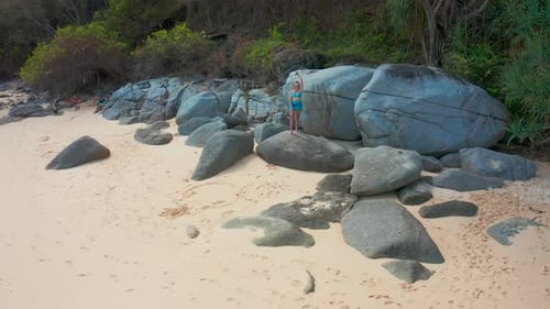 Woman in Bikini Standing on Rocky Stone Enjoying Summer Vacation Resting on Tropical Sea Shore