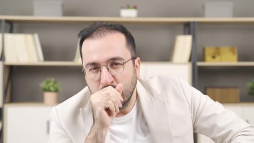 Man with Glasses Coughing Indoors