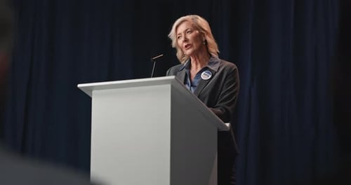 Woman Speaking at Podium During Corporate Conference