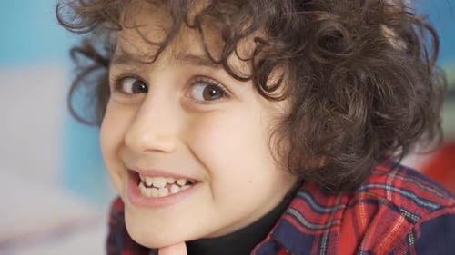 Un garçon drôle qui regarde la caméra et rit. Souriez.