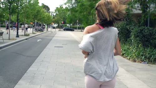 Young woman's urban jogging workout in super slow motion city fitness training