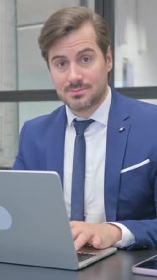 Man in Suit Types on Laptop and Gives Thumbs Up
