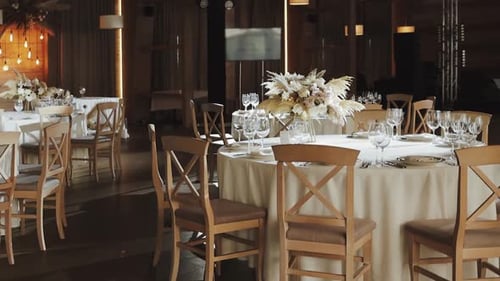 Elegant Wedding Hall with Flower Decorations and Wooden Chairs