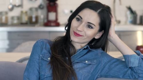 Smiling Woman Relaxing on Sofa at Home