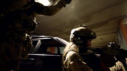 Deux soldats sortent de la voiture pour se préparer à une opération tactique Les points lumineux sur le béton