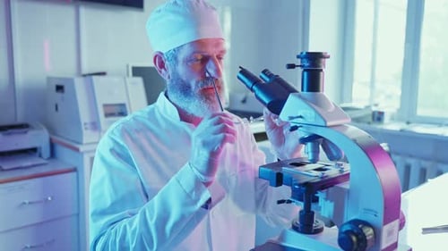 Bearded Scientist Analyzing Sample with Microscope in Lab