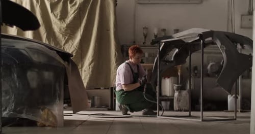 Female Painter Sanding Bumper for Priming