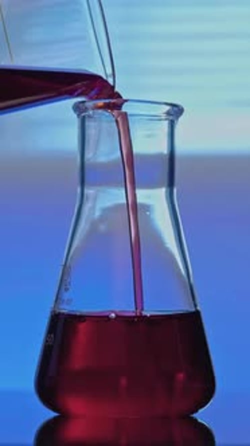 Red Liquid Being Poured into Flask in Laboratory