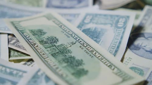 US One Hundred Dollar Bills Falling Onto Pile of Money in Slow Motion