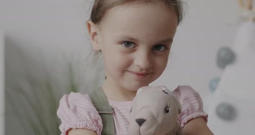 Smiling Girl Holding Her Stuffed Animal Close