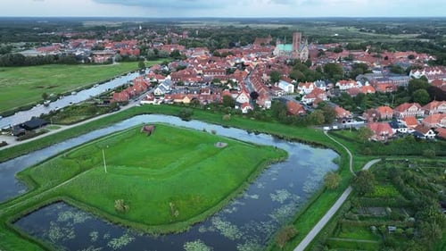 Aerial footage over Riberhus Castle Bank by historic town of Ribe, with the majestic Ribe Cathedral,