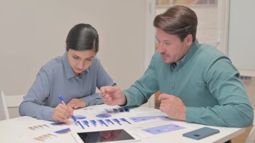 Professionals Analyzing Charts and Business Documents