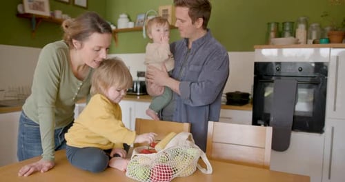 Family with Children Enjoys Fresh Vegetables in Kitchen