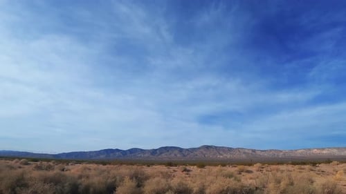 Looking out the side window as the vehicle travels through the Mojave Desert landscape - passenger p