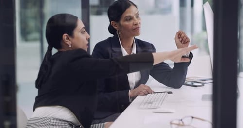 4k video footage of two businesswomen working together on a computer in an office