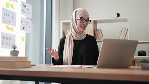 Young Woman in Headscarf Leads Virtual Meeting