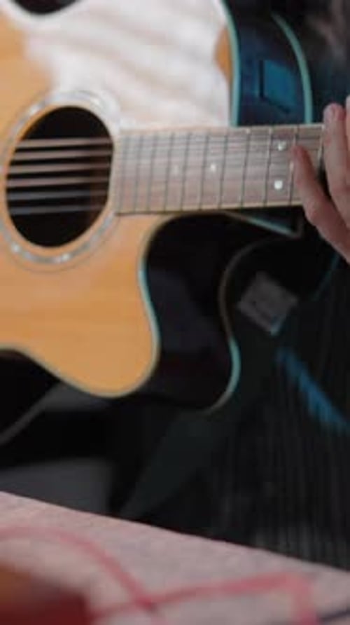 Man Playing Acoustic Guitar in Dimly Lit Studio