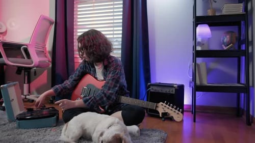Person Plays Guitar and Record Player at Home