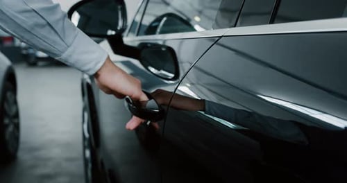 Close up of young businessman hand opening an anonymous car just bought from auto deal. Slow motio