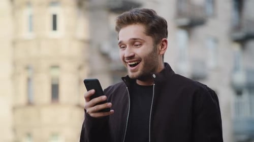 Excited man celebrates success looking at smartphone screen