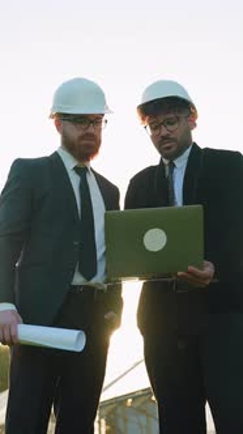 Investors Discussing Project on Laptop at Construction Site