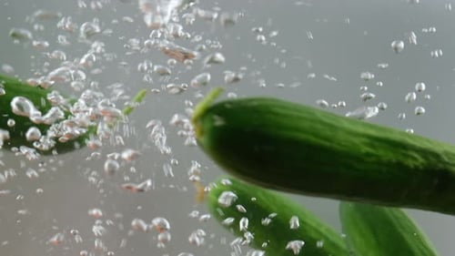 Cucumbers Floating in Water with Bubbles