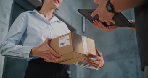 Close Up of Postman Delivering Parcel Box to Addressee Getting Client's Signature on Digital Tablet