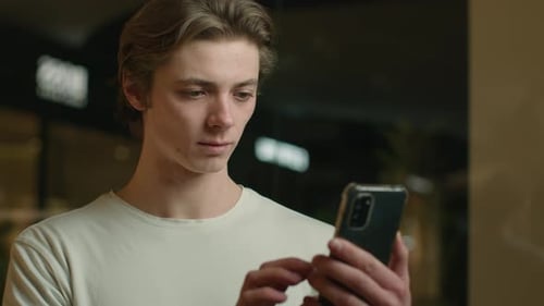 Young Adult Reacts to Smartphone News With Celebration