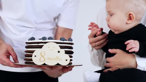 Eight-Month-Old Baby with Parents and Birthday Cake