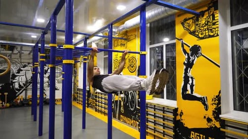Young Muscular Athlete Showing Some Gymnastics Stunts on Horizontal Bar at Sport Club Strong Sporty