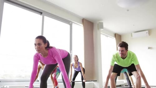 Group of People Exercising with Bars in Gym Active