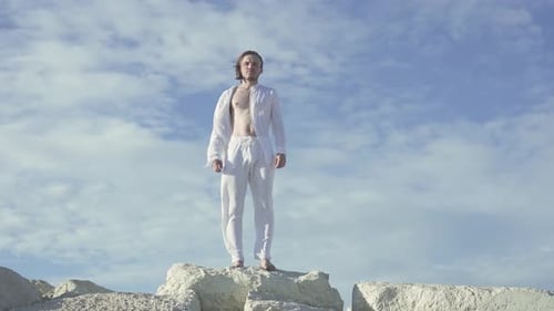 Young Adult Standing on Rocks by Ocean