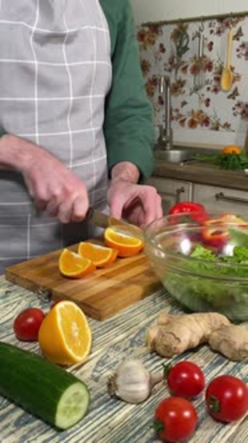 Person Cutting Orange in Kitchen for Salad