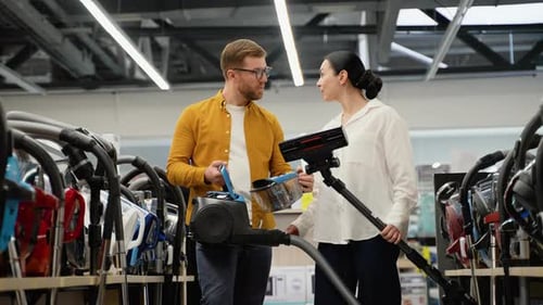 Young Couple Buying New Vacuum Cleaner at Tech Store
