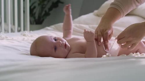 Adorable Baby Getting Diaper Changed on Bed