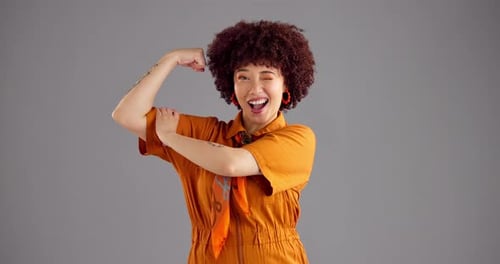 Wink, muscle and face of woman in studio for empowerment, strength and confidence