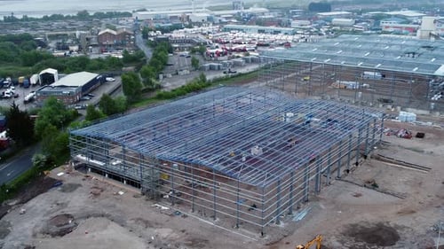 Sitio de construcción de edificio industrial moderno sin terminar, estructura de acero, vista aérea, inclinación desde arriba