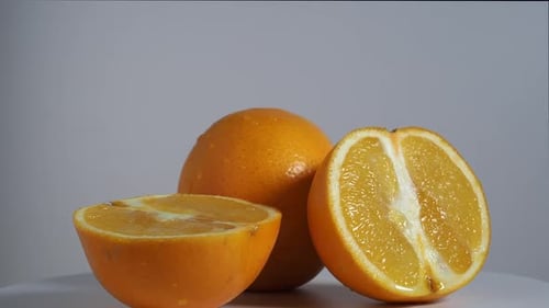Rotating Ripe Orange. Fresh juicy orange on a light background. Close-up. High quality 4k footage
