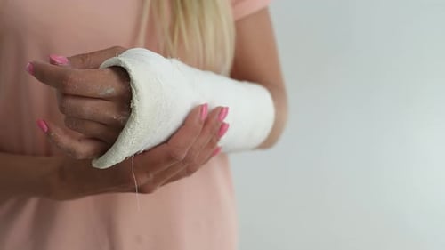 Closeup Cropped Shot of Unrecognizable Young Woman with Broken Arm Wrapped in White Plaster Bandage