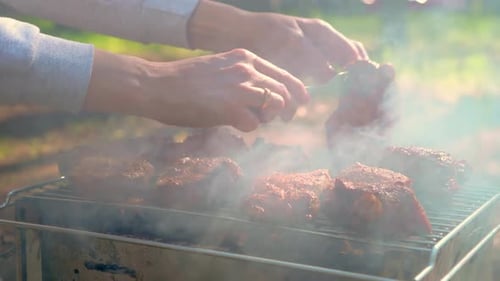 Unrecognizable Woman Cooking Meat on Grill Smoke From BBQ Filling Air