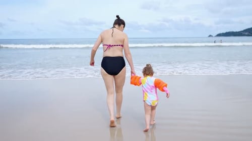 Mother and Daughter Walking on the Beach