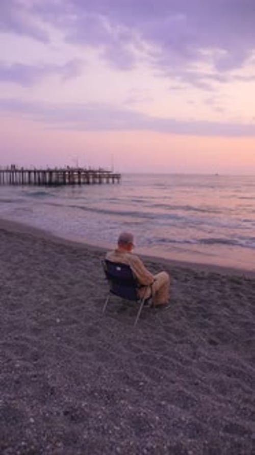 A Serene Beach Sunset Featuring a Figure Standing on the Warm Sand By the Coastline