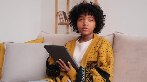Young Woman Using Tablet While Sitting on Couch