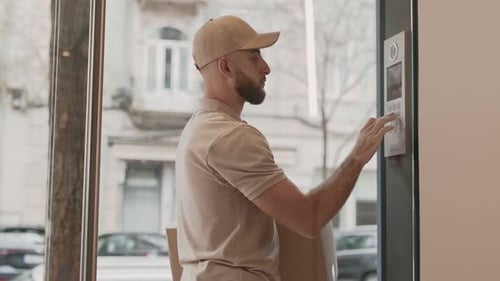 Courrier de livraison utilisant un interphone pour entrer dans l'immeuble