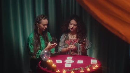 Female Client and Tarot Specialist Discussing Layout during Session with Wine