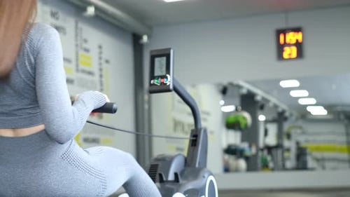 Female Athlete Trains on the Simulator Fitness Girl Works in the Gym