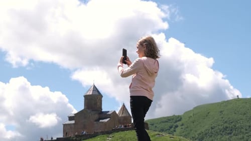 Girl Taking Photos Over Gergeti Trinity Church